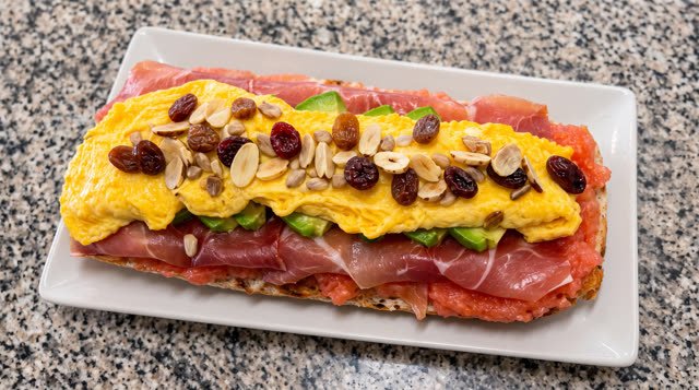 Tostada especial de la casa: tomate, jamón serrano, aguacate, tortilla francesa y frutos secos